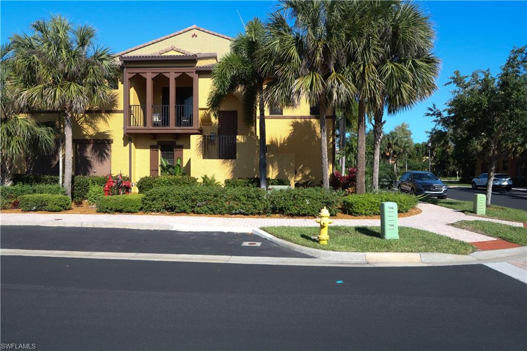 9114 Capistrano Street South, Unit 8501 Naples, FL 34113 - Photo 24 of 26 a front view of a house with a yard and palm trees