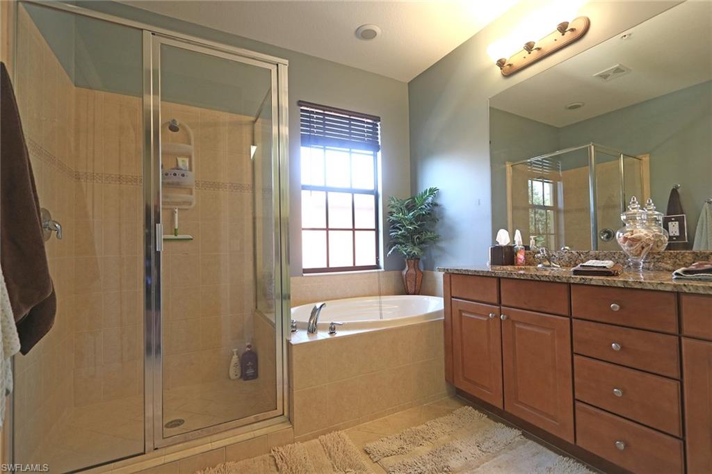 9114 Capistrano Street South, Unit 8501 Naples, FL 34113 - Photo 8 of 26 a bathroom with a tub a sink shower and mirror