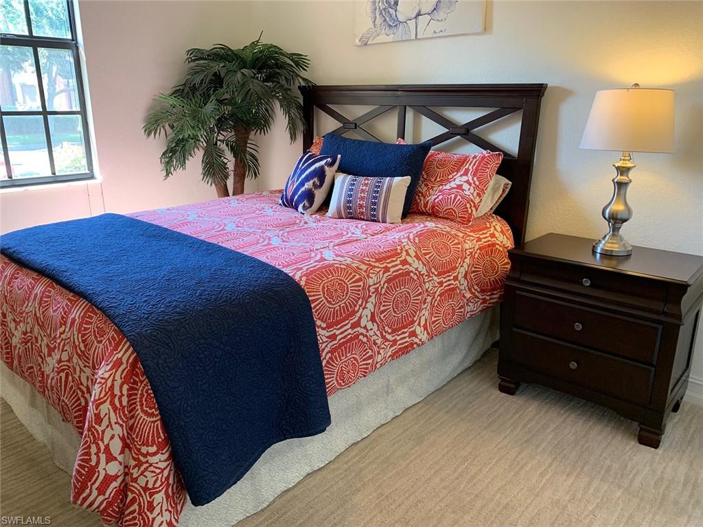 9114 Capistrano Street South, Unit 8501 Naples, FL 34113 - Photo 9 of 26 a bedroom with a bed and a potted plant