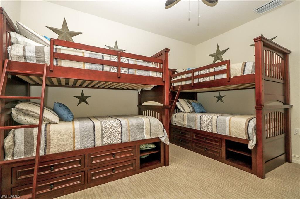 9114 Capistrano Street South, Unit 8501 Naples, FL 34113 - Photo 10 of 26 a bedroom with bed and a chandelier
