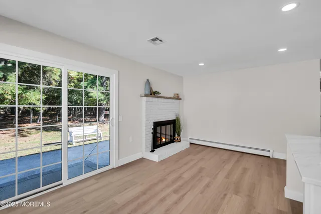 a view of empty room with wooden floor and fireplace