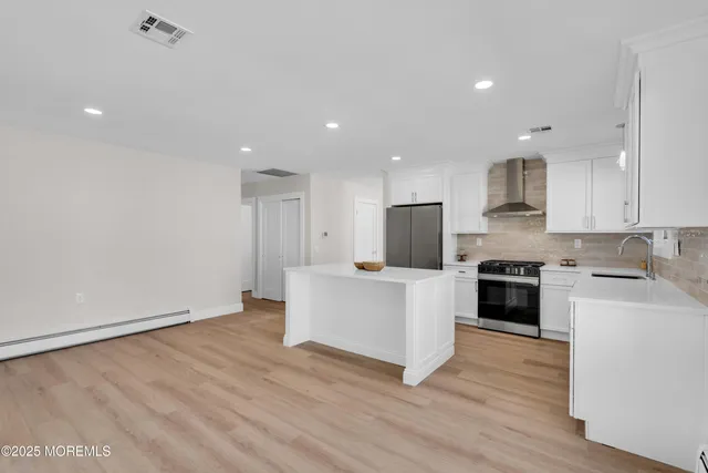 a kitchen with white cabinets and stainless steel appliances