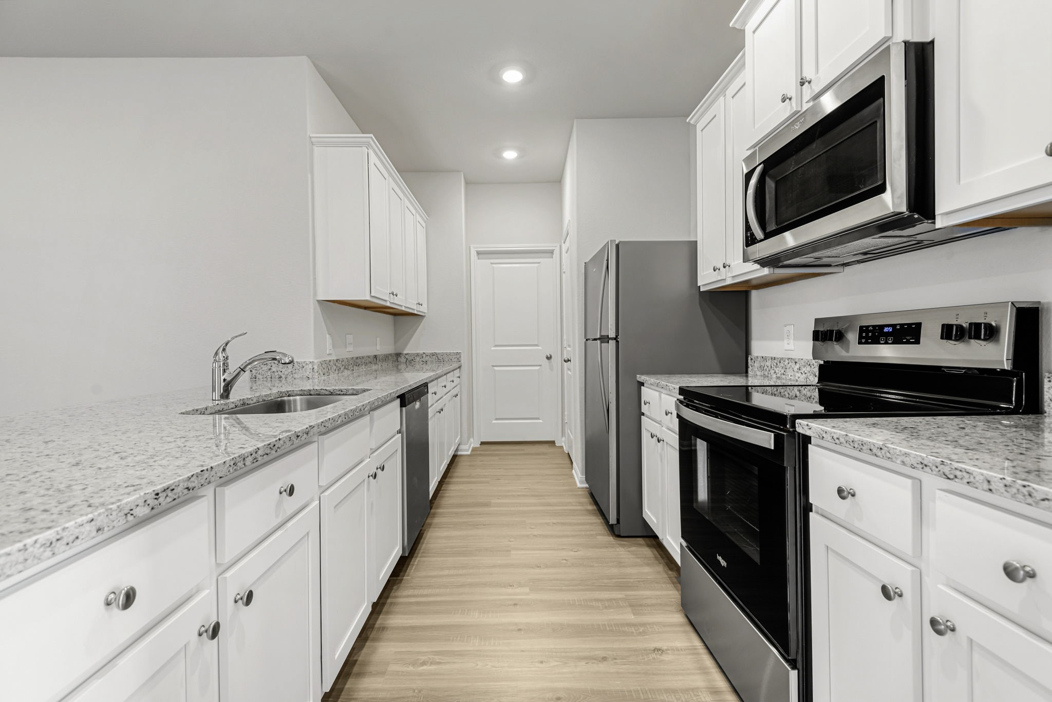 a kitchen with granite countertop a sink and steel appliances