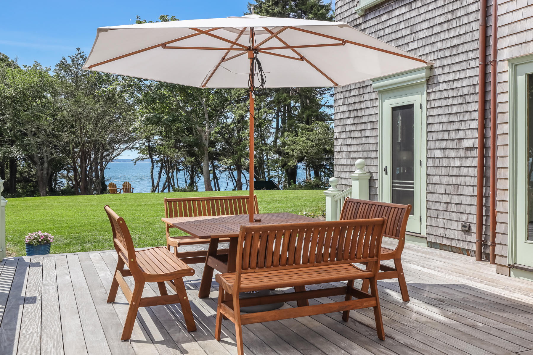 39 Juniper Point Road Woods Hole, MA 02543 - Photo 11 of 53 a view of a chair and table on the wooden deck
