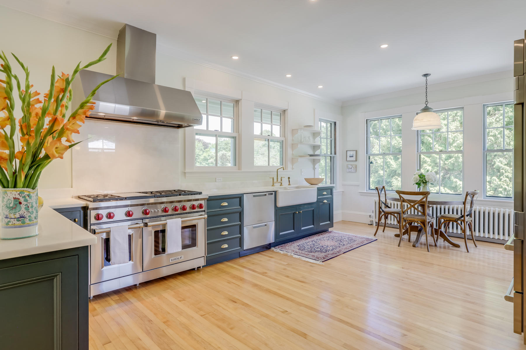 39 Juniper Point Road Woods Hole, MA 02543 - Photo 23 of 53 a kitchen with stainless steel appliances a stove a sink a dining table and chairs with wooden floor