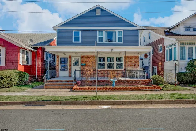 a view of a brick house with a yard in front of it