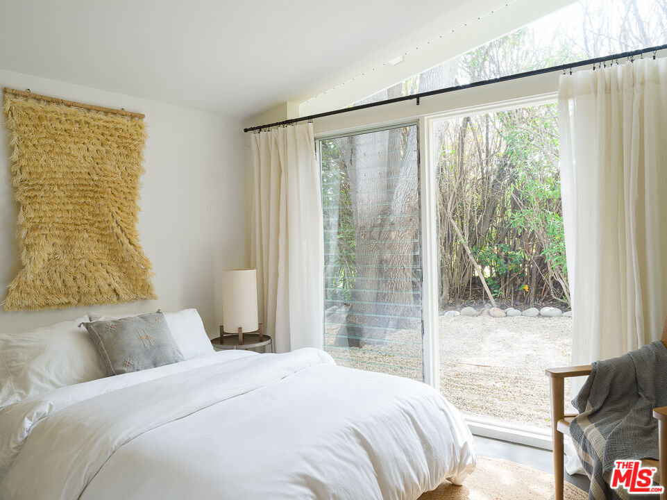 29107 Cliffside Drive Malibu, CA 90265 - Photo 15 of 22 a bedroom with a large bed and a large window with outer view