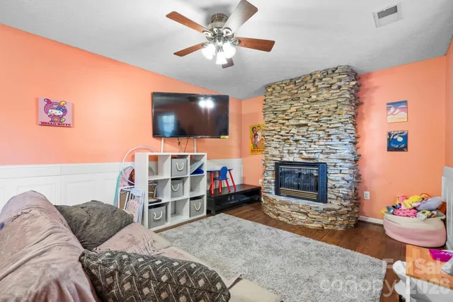 a living room with furniture a flat screen tv and a fireplace