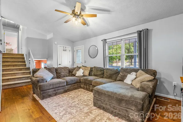 a living room with furniture ceiling fan and a rug