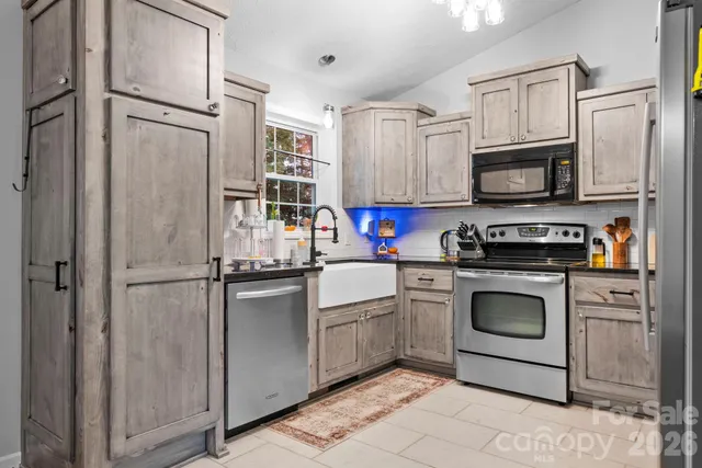 a kitchen with stainless steel appliances granite countertop a refrigerator sink stove microwave and cabinets