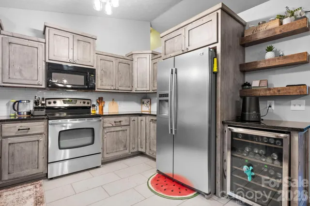 a kitchen with stainless steel appliances granite countertop a refrigerator sink and stove