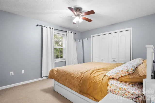 a bedroom with a bed and a large window