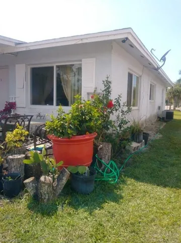 a front view of a house with a yard and potted plants
