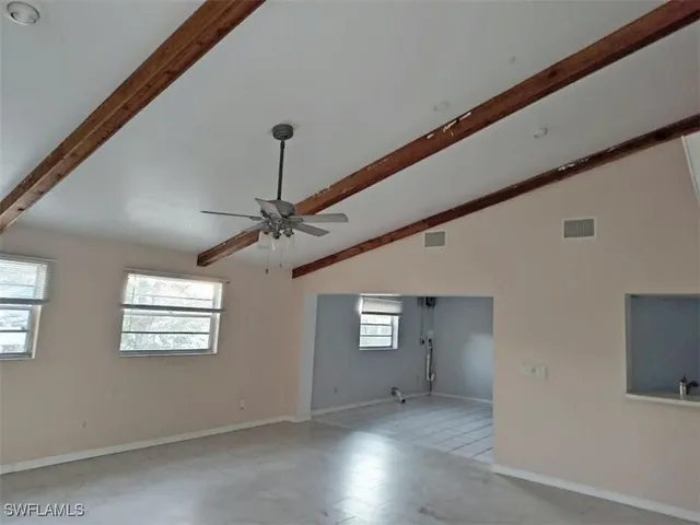 an empty room with windows and ceiling fan