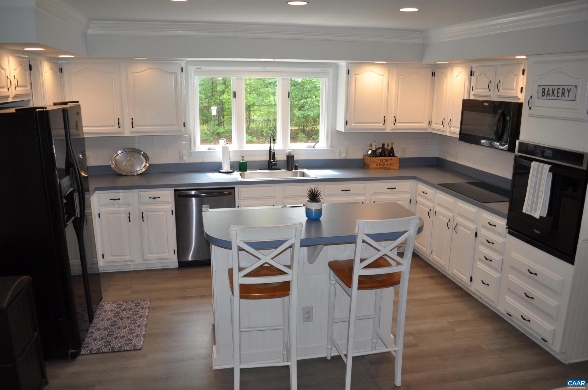 3257 Martin Kings Road Charlottesville, VA 22902 - Photo 13 of 49 a kitchen with stainless steel appliances granite countertop a stove a sink a microwave a refrigerator and white cabinets with wooden floor