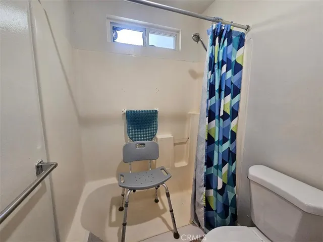 a bathroom with a toilet and a shower