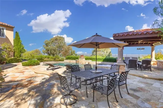 a view of a dining room with furniture one side kitchen view and wooden floor