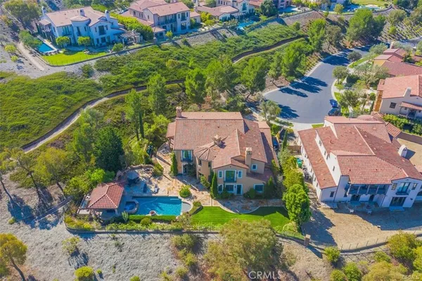 an aerial view of residential houses with outdoor space and trees