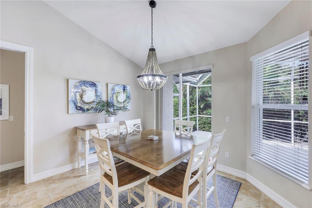 31 Tahiti Road Marco Island, FL 34145 - Photo 6 of 27 a dining room with wooden floor a chandelier a wooden table and chairs