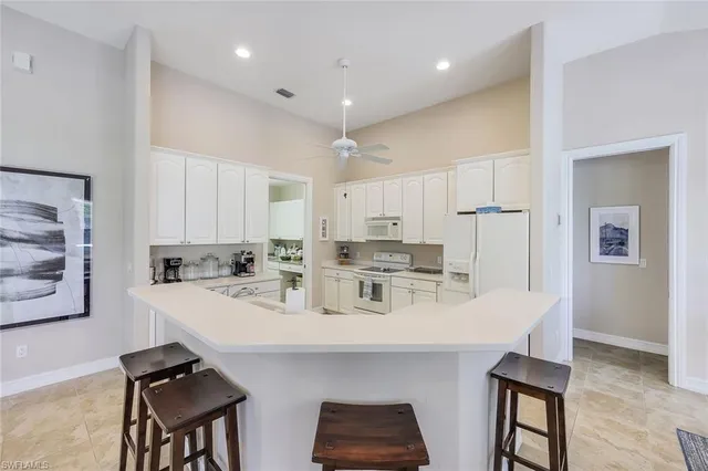 a kitchen with stainless steel appliances kitchen island granite countertop a sink a stove and chairs