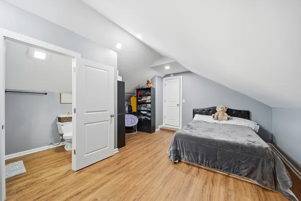 a bedroom with a bed and wooden floor