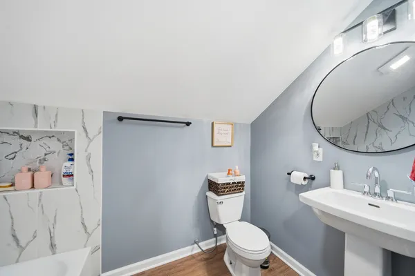 a bathroom with a toilet sink vanity and mirror