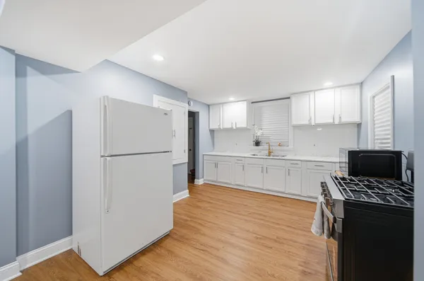 a kitchen with a refrigerator and a stove top oven