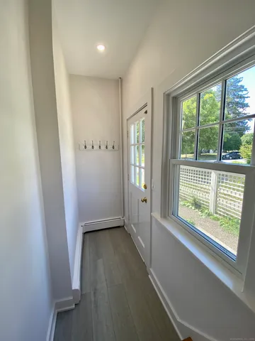 a view of hallway with windows and wooden floor