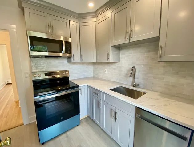 a kitchen with stainless steel appliances granite countertop a sink stove and microwave