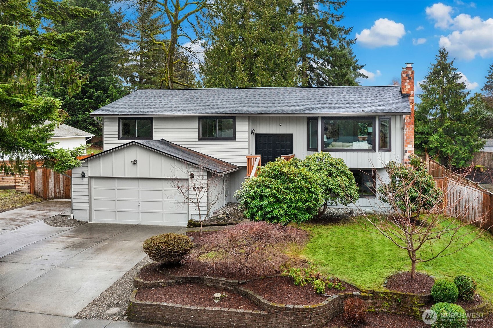 10017 Northeast 202nd Street Bothell, WA 98011 - Photo 1 of 38 a view of a house with a yard plants and a large tree