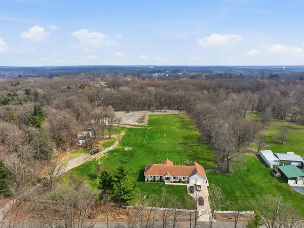an aerial view of house with yard and mountain view in back