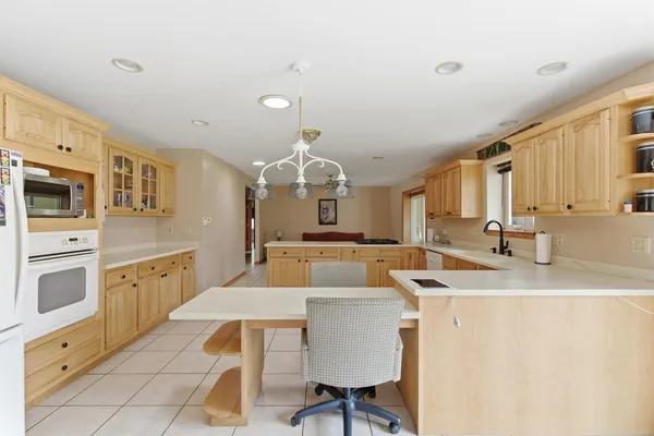 a kitchen with stainless steel appliances granite countertop a sink a stove a refrigerator a microwave oven with white cabinets and wooden floor