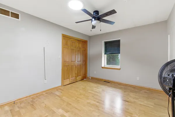 a view of a big room with wooden floor and windows