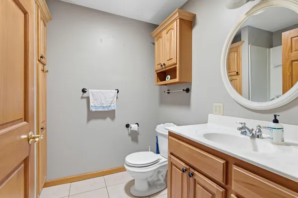 a bathroom with a granite countertop toilet sink and mirror