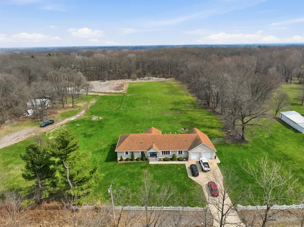a aerial view of a house with yard and mountain view in back