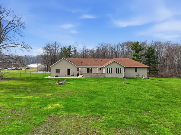 a view of a big house with a big yard and large trees