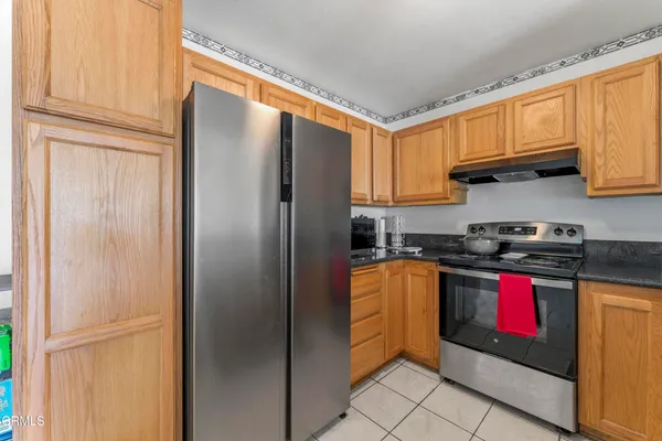 a kitchen with stainless steel appliances granite countertop a refrigerator and a stove