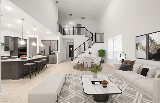 a living room with furniture kitchen view and a chandelier