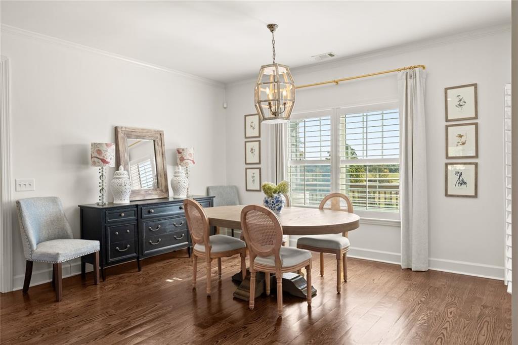 360 Clear View Court Clermont, GA 30527 - Photo 14 of 53 a dining room with wooden floor a chandelier a wooden table and chairs