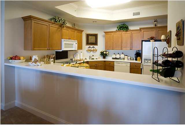 5 Calhoun Avenue, Unit 606 Destin, FL 32541 - Photo 6 of 18 a kitchen with stainless steel appliances wooden cabinets and a counter top space