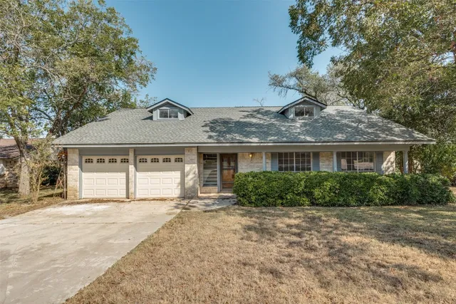 a front view of a house with a yard and potted plants