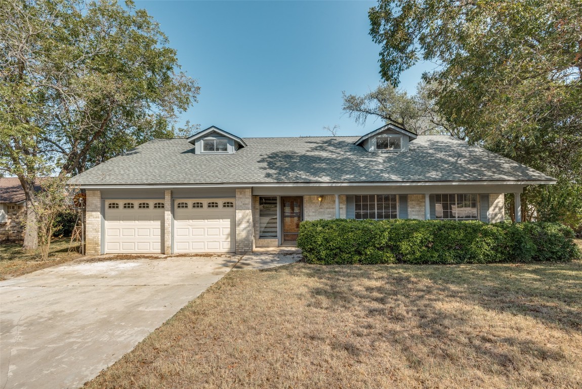 a front view of a house with a yard and potted plants