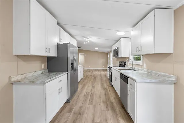 a kitchen with a stove a sink a refrigerator and cabinets