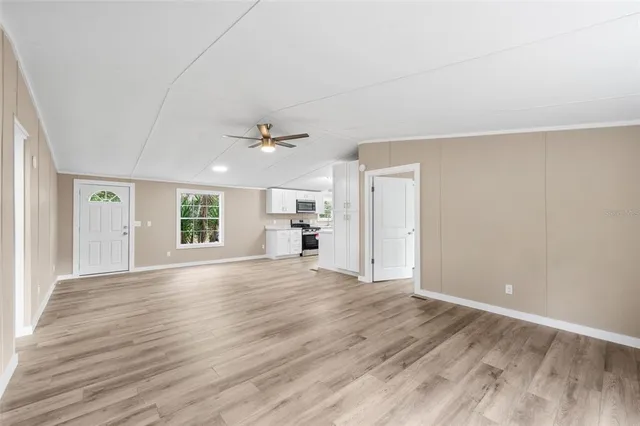 a view of empty room with wooden floor and window