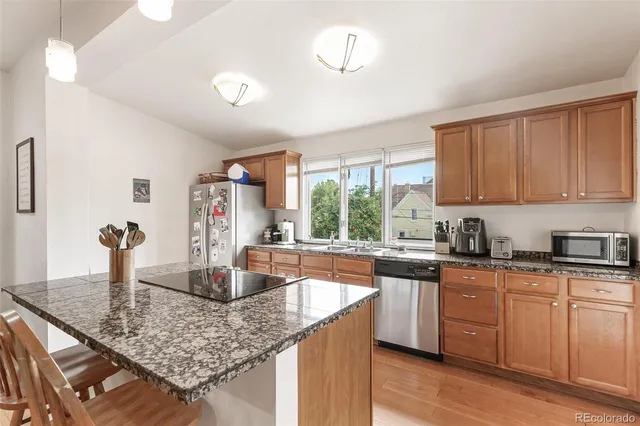 a kitchen with stainless steel appliances granite countertop a sink stove and cabinets