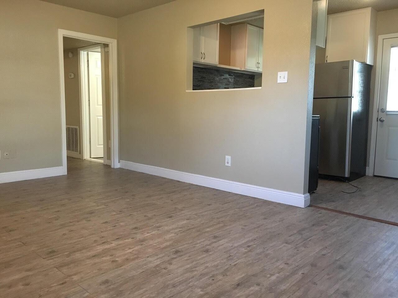 4501 45th Street Lubbock, TX 79414 - Photo 2 of 9 a view of an empty room with wooden floor and a window