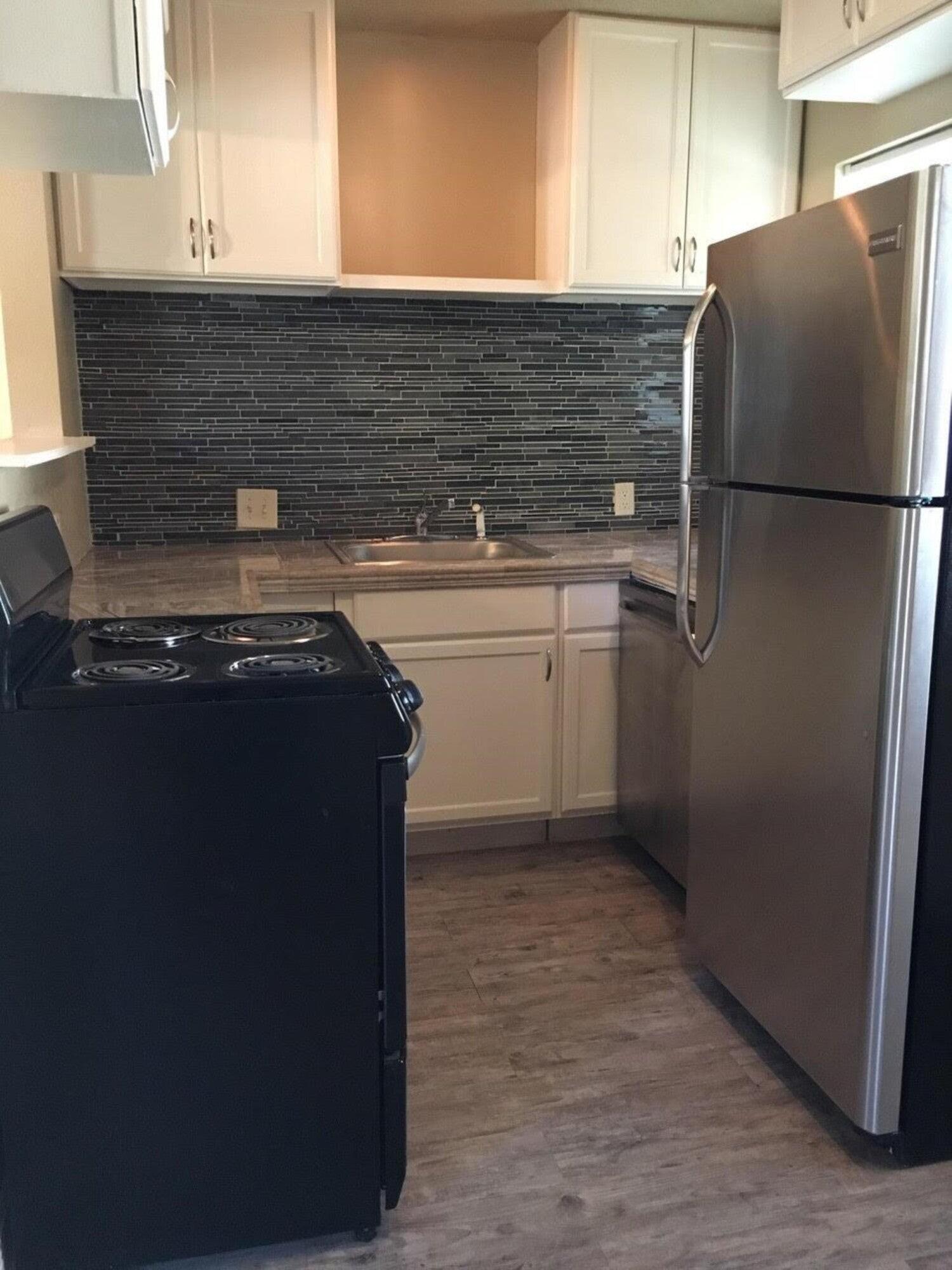 4501 45th Street Lubbock, TX 79414 - Photo 3 of 9 a kitchen with granite countertop a refrigerator and a sink