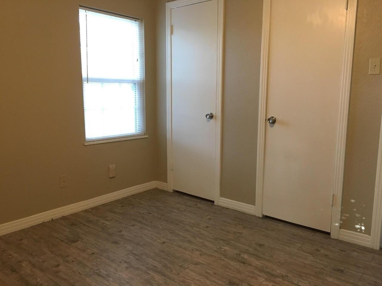 4501 45th Street Lubbock, TX 79414 - Photo 7 of 9 an empty room with wooden floor and windows