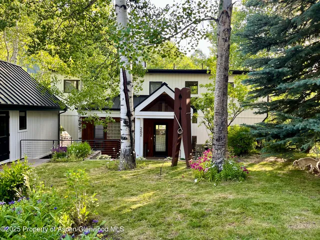 a view of a house with a yard and tree s