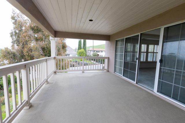 a view of a kitchen with kitchen island a sink wooden floor and stainless steel appliances